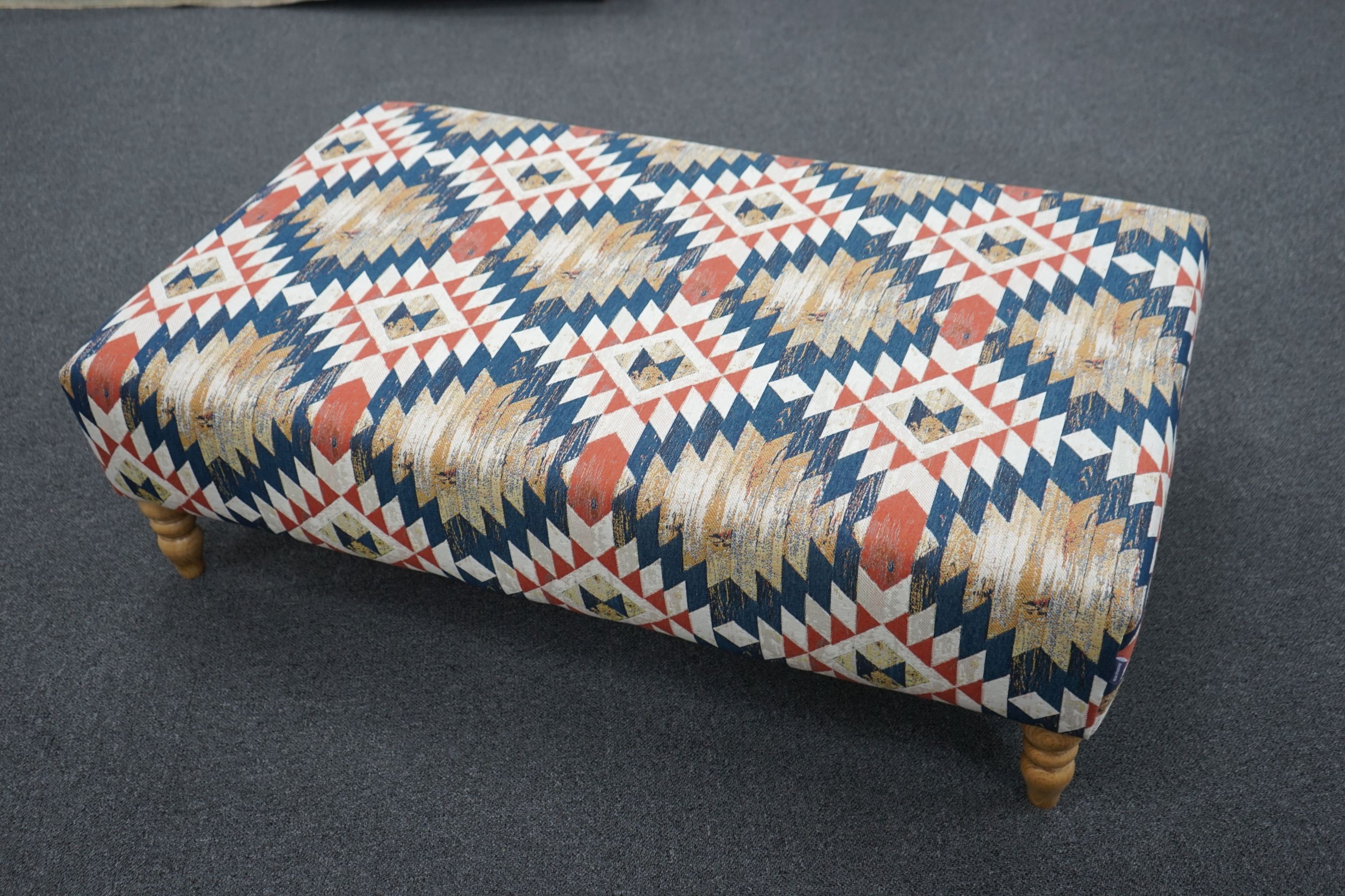 A large contemporary rectangular coffee table / footstool upholstered in Kilim style polychrome fabric on turned feet, length 122cm, depth 72cm, height 38cm